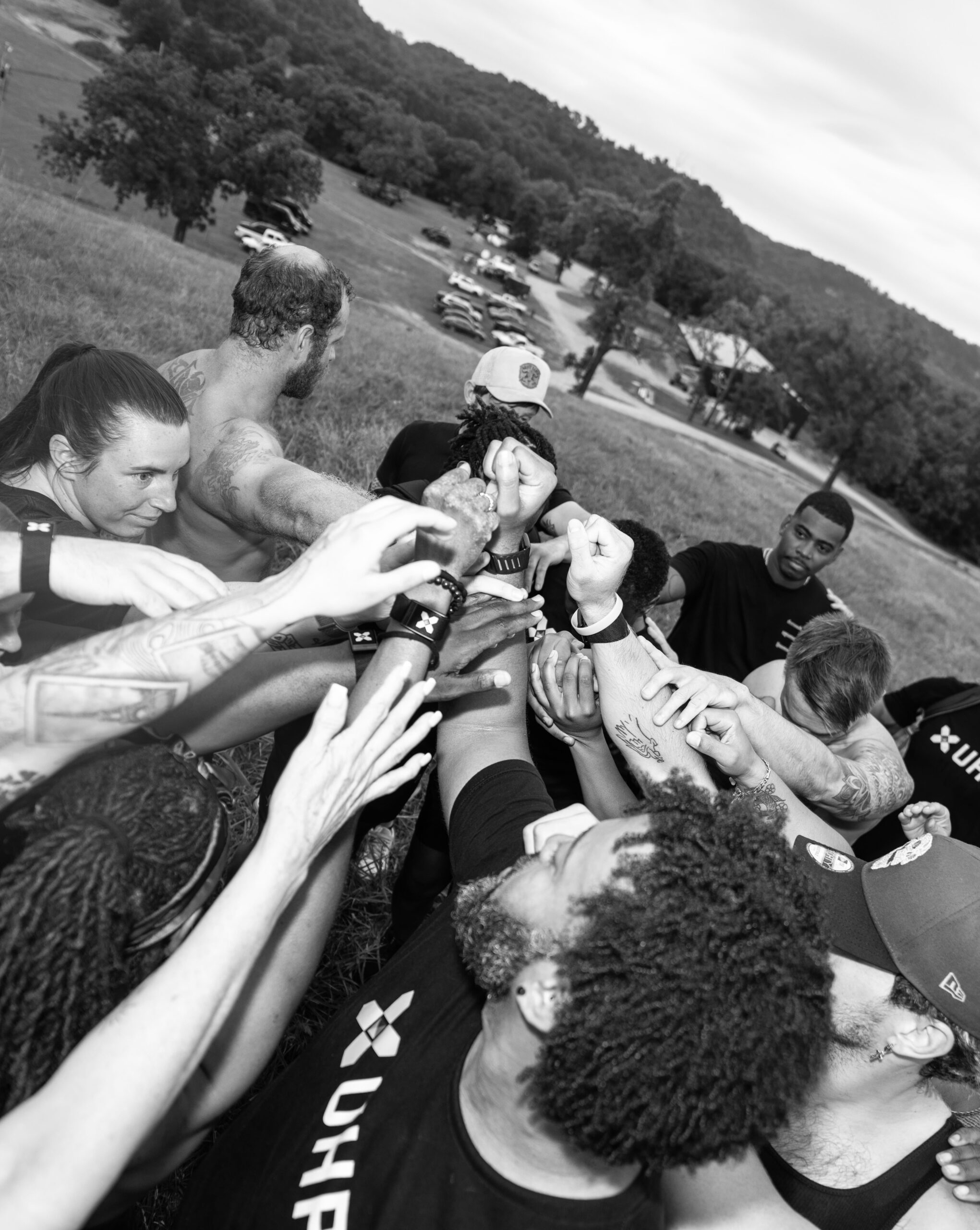 A team huddle with hands in on the campus training floor