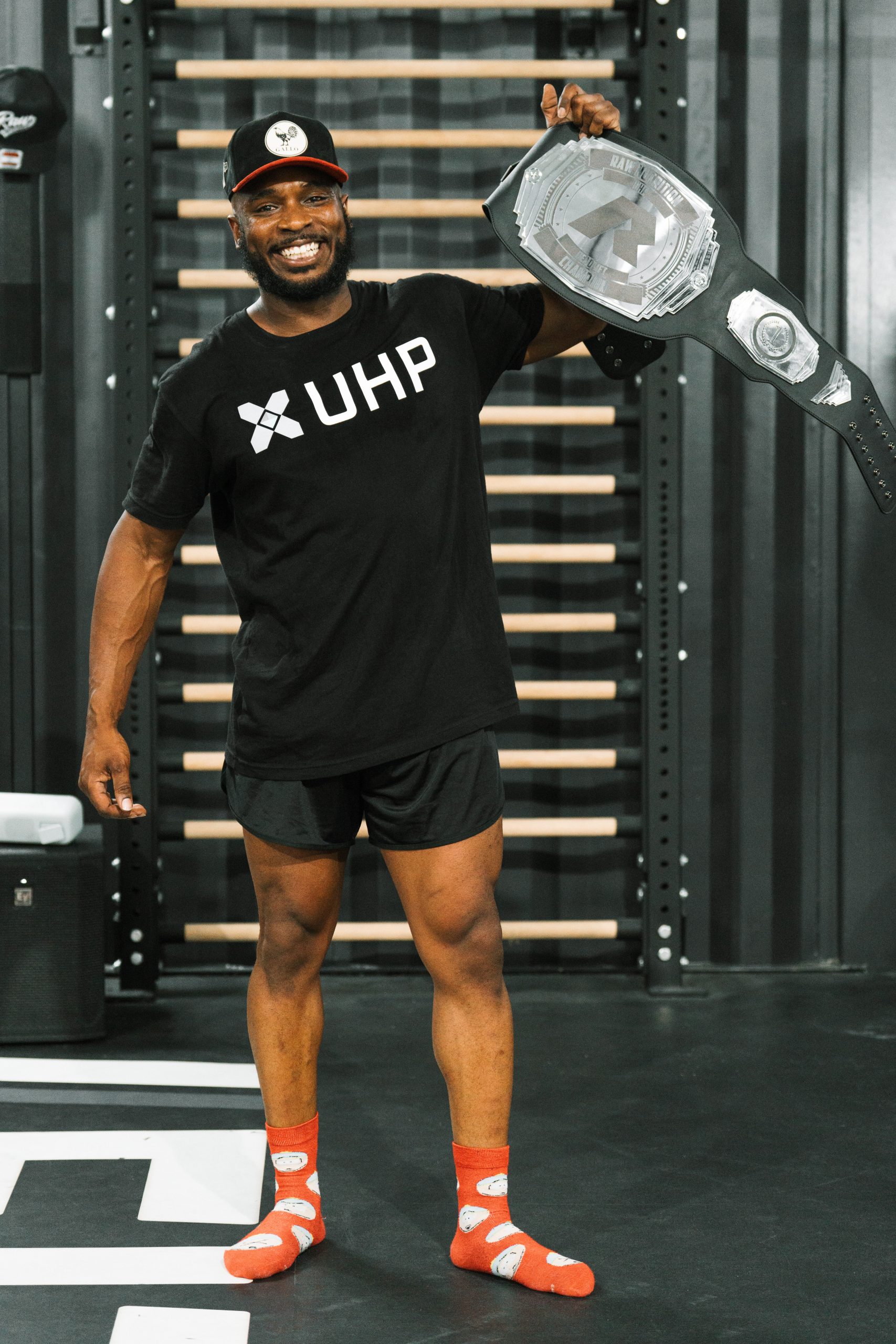 partner-raw A UHP athlete holding a RAW championship belt